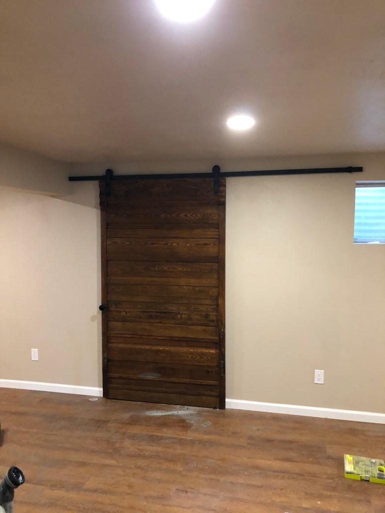 Barn door. Wood barn door. Custom built barn door. Luxury vinyl plank flooring. Basement remodel. Recess lighting