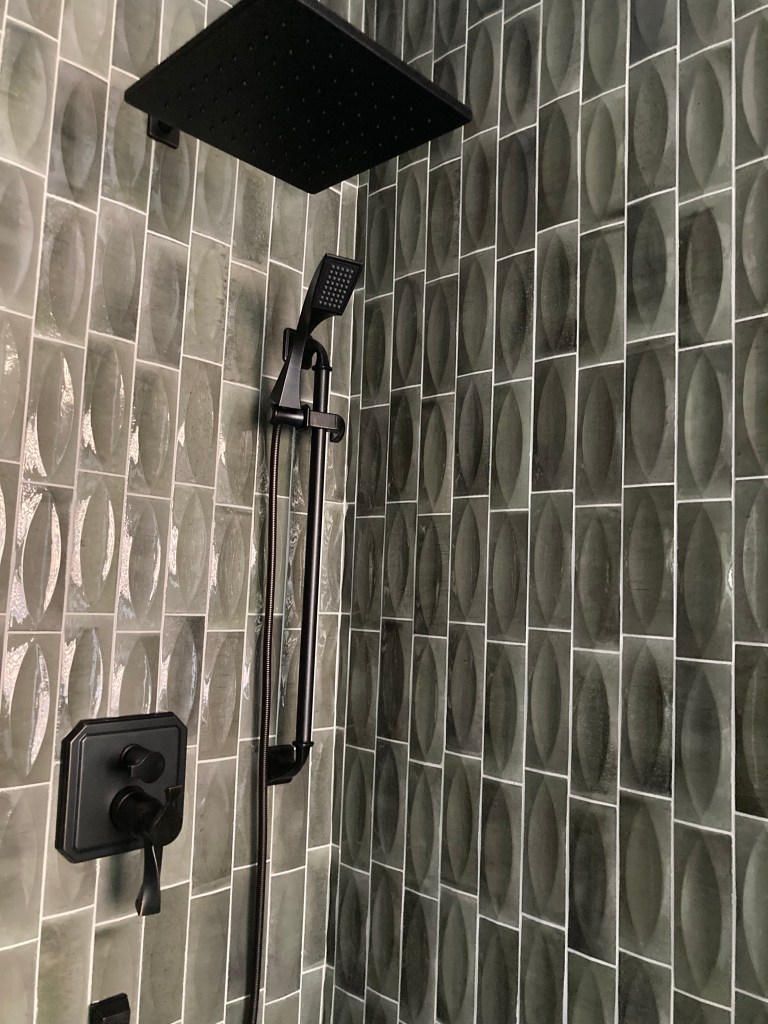 Shower update. Grey textured tile with matte black hardware. unique tile layout. Bathroom update remodel