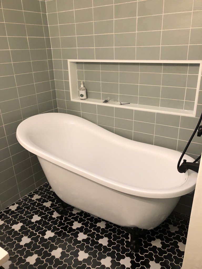 Bathroom update. Mosaic tile floor. grey subway tile. Shower niche. freestanding tub. Clawfoot tub and shower. Matte black. Modern and contemporary bathroom.